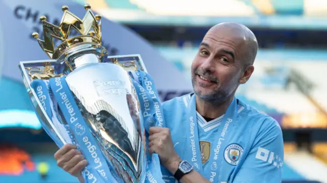 Manchester City manager Pep Guardiola celebrates after winning a fourth straight Premier League title