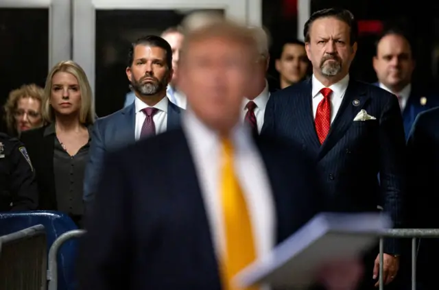 Pam Bondi, former attorney general of Florida, from left, Donald Trump Jr., executive vice president of development and acquisitions for Trump Organization Inc., and Sebastian Gorka, former Deputy Assistant to the President of the United States, watch as former US President Donald Trump, center, speaks to members of the media at Manhattan criminal court in New York