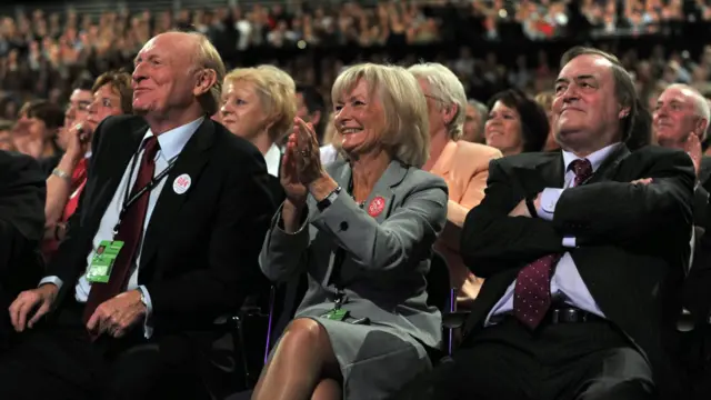 Neil Kinnock, Glenys Kinnock and John Prescott sat with a big crowd behind them