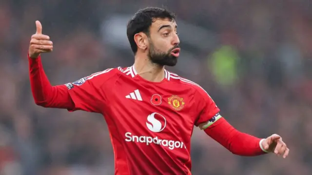 Manchester United midfielder Bruno Fernandes gestures in a home shirt at Old Trafford