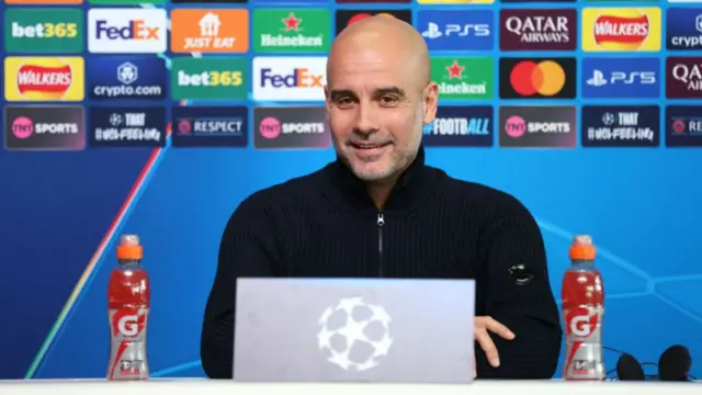 Pep Guardiola smiles at a news conference