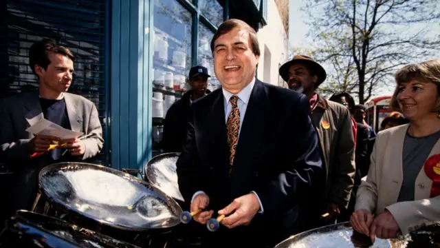 John Prescott campaigning in London in 1997. He's standing surrounded by other Labour activists as he holds two steel drum sticks