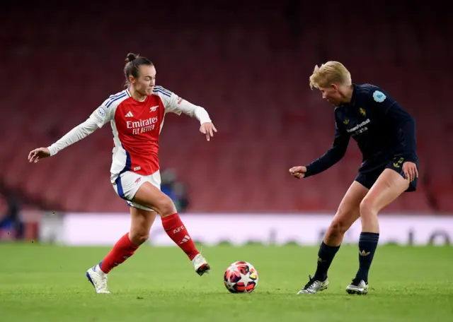 Caitlin Foord of Arsenal is challenged by Paulina Krumbiegel