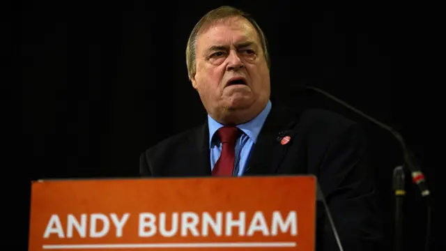 John Prescott giving a speech with a sign supporting Andy Burnham's leadership campaign