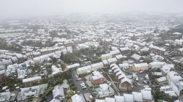 Aerial view of snowy roofs in Bridport. The sky is white and murky.