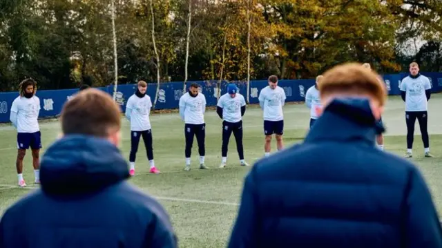 Players taking part in the one-minute silence at the club