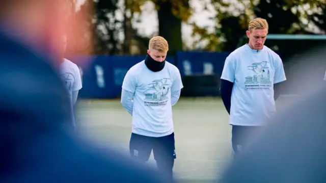 Players taking part in the one-minute silence at the club