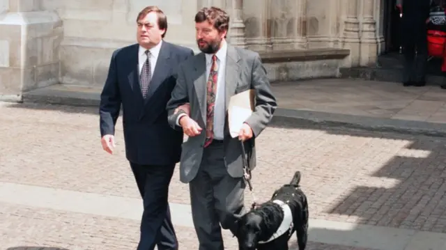 John Prescott walking with David Blunkett and his guide dog