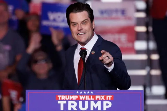 Matt Gaetz behind a podium gesturing towards a crowd