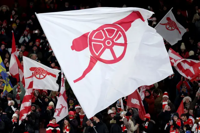 Arsenal fans hold up a flag