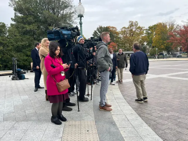 Reporters stand outside the Capitol