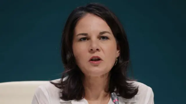 Annalena Baerbock speaking into a microphone at COP29