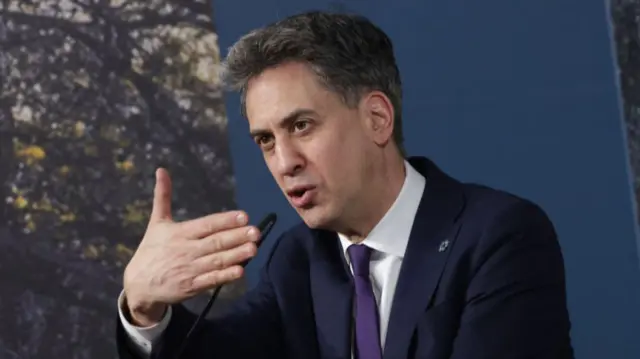 Ed Miliband, in a suit, delivering a speech at COP29