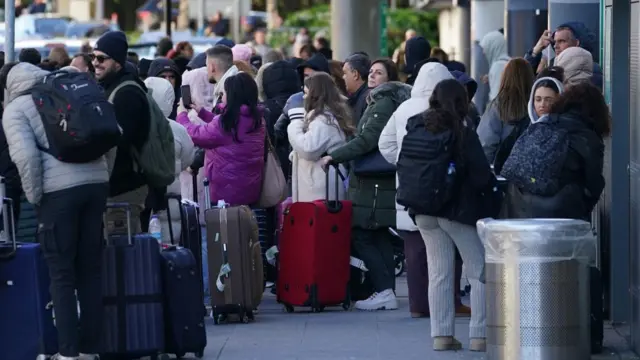 People stood with suitcases outside Gatwick Airport