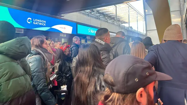 A queue of people at Gatwick Airport.