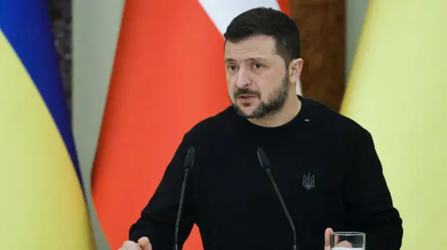 Ukrainian President Volodymyr Zelensky addresses a joint press conference in black jumper, speaking into microphones