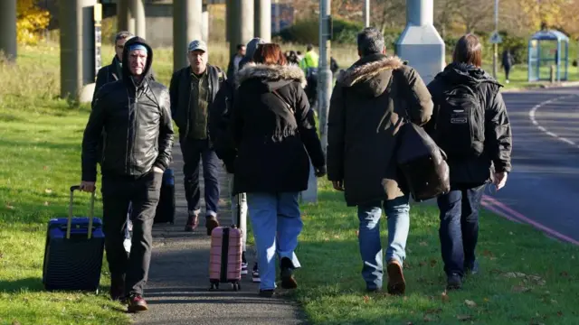 Group shot of people walking along the pavement near Gatwick