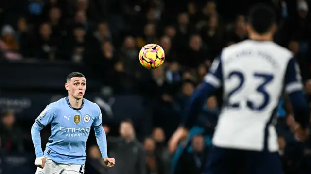 Phil Foden (L) eyes the ball