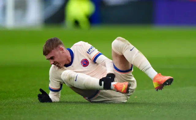 Chelsea's Cole Palmer sits injured after a challenge from Leicester City's Wilfred Ndidi