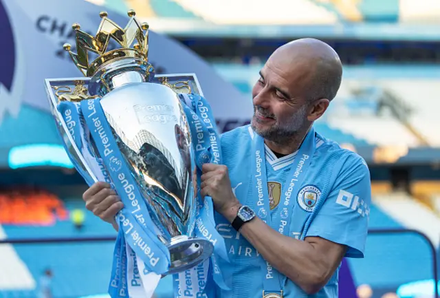 Pep smiling with the Premier League trophy