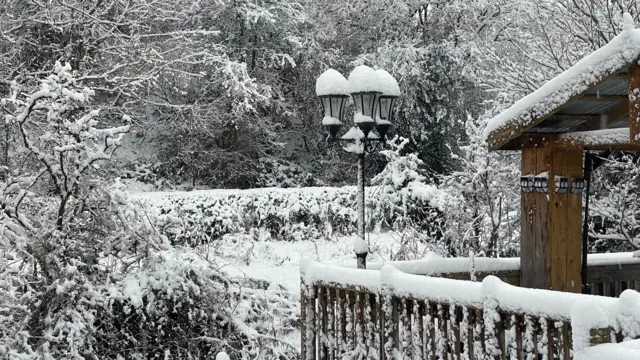 Snow covered house and street lamp