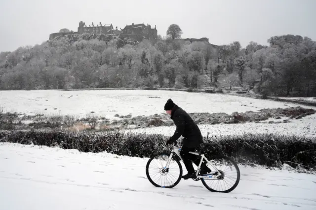 A person rides a bicycle in the snow at Stirling Castle, Stirling, Scotland. Storm Bert is battering the country with strong winds, heavy rain and snow and ice with amber warnings coming into force bringing a "potential risk to life and property".