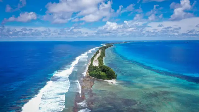 Aerial view of Tuvalu from Drone. Island, water, ocean, palm trees, waves.