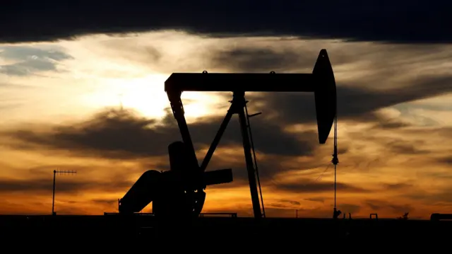 he sun sets behind a crude oil pump jack on a drill pad in the Permian Basin in Loving County, Texas, U.S.