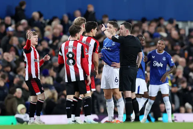 Christian Norgaard of Brentford interacts with match referee Chris Kavanagh