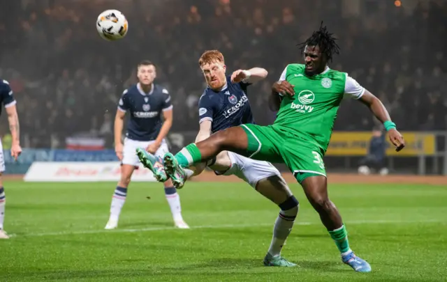 DUNDEE, SCOTLAND - NOVEMBER 23: Dundee's Simon Murray and Hibernian's Rocky Bushiri in action during a William Hill Premiership match between Dundee and Hibernian at the Scot Foam Stadium at Den's Park on November 23, 2024, in Dundee, Scotland. (Photo by Euan Cherry / SNS Group)