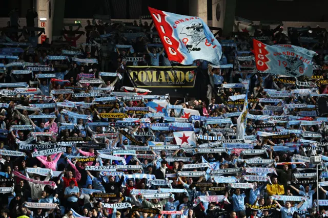 Celta fans belt out the club anthem and hold aloft scarves before kick off