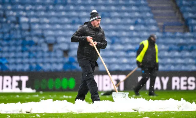 Ground staff at Ibrox clearing the pitch