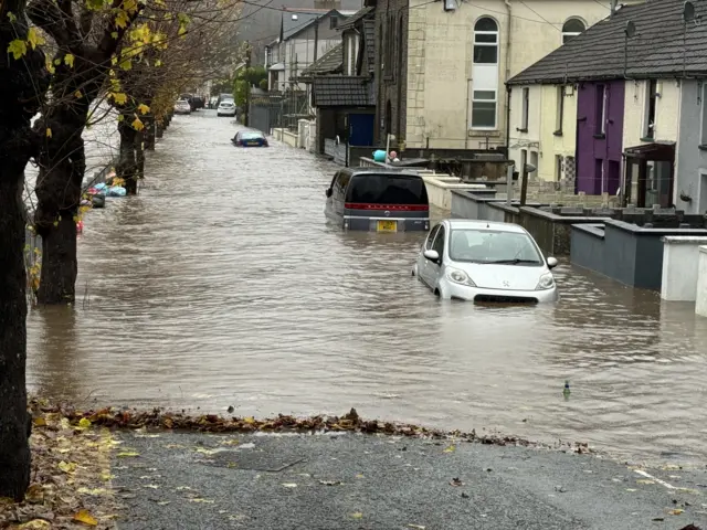 Cars under water along a residential street in Pontypridd