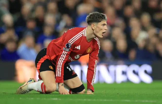 Garnacho kneels on the floor after being knocked over