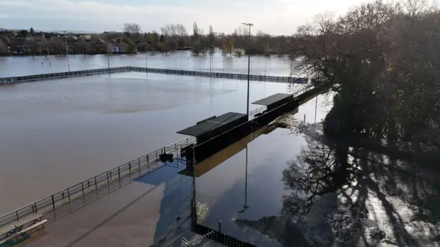 Flooded sports pitch from a drone. The field behind the pitch is also flooded.