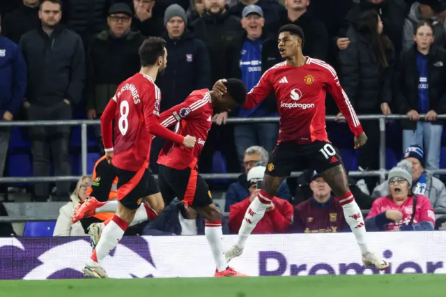 Marcus Rashford celebrates with Amad Diallo and Bruno Fernandes after scoring against Ipswich