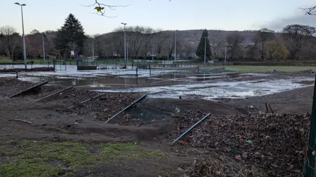 Flattended fences and flooded tennis courts at Pontypridd Lido