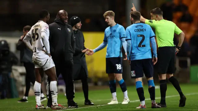 Port Vale manager Darren Moore protests as Rekeem Harper is sent off