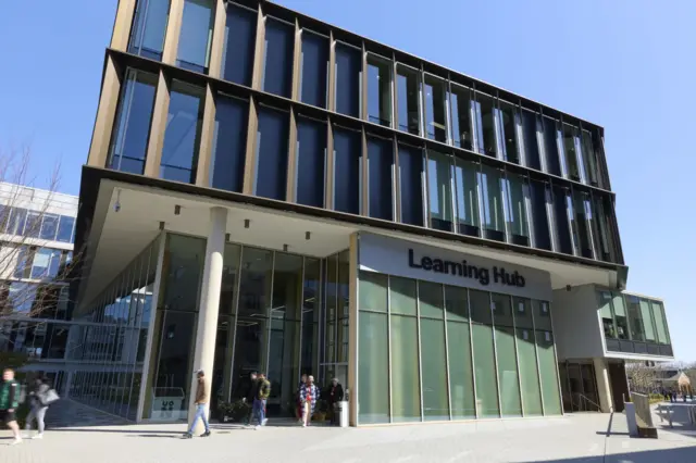 University of Northampton building with students walking out of it. The building says 'Learning Hub' on it