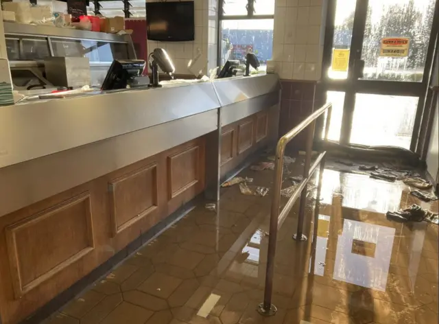 Flooded floor inside Ruddy's Fish& Chip Shop. Pieces of rubbish are among the floodwater.