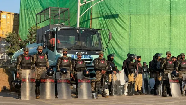 Soldiers standing in front of a wall of containers