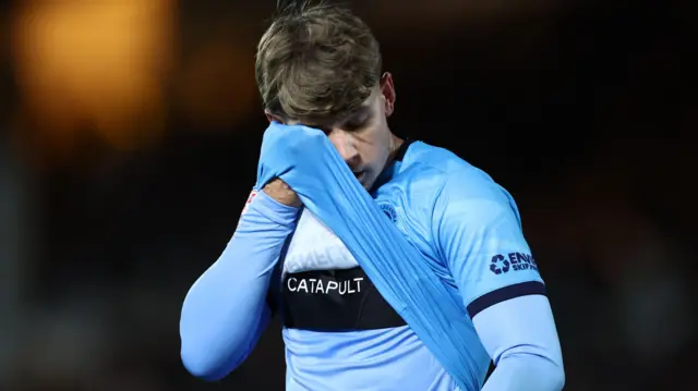 Crewe's Max Sanders wipes his face with his shirt