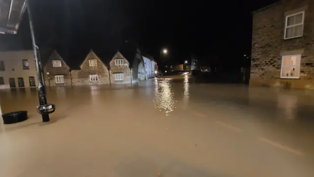 A view of floodwater on a road - teh entire road is submerged