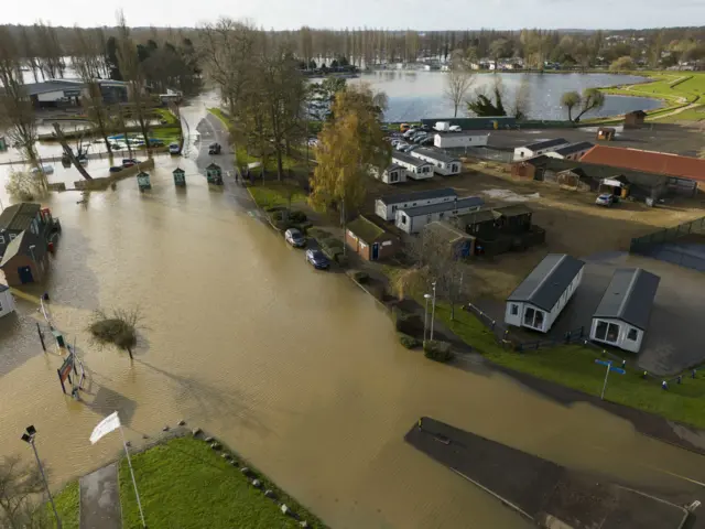 A drone picture of Billing Aquadrome which is heavily submerged in brown flood water. Roads throughout the site are completely covered with water