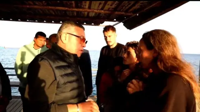 'Red Sea Governor Amr Hanafi speaks to survivors at a harbour