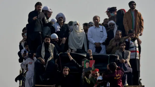 Bibi and a number of others, on top of what seems to be a car