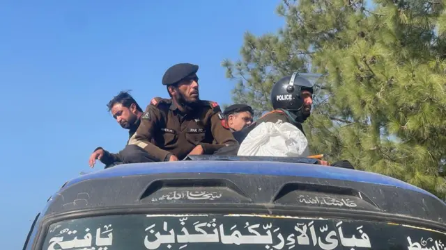 Paramilitary officers sitting on top of a coach