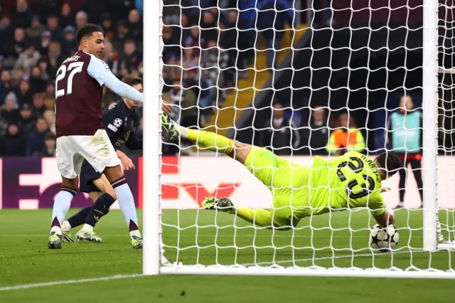 Emiliano Martinez of Aston Villa makes a save off a shot from Andrea Cambiaso