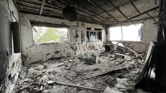 A house that is completed ruined inside and looks like it's burned down, with rubble everywhere
