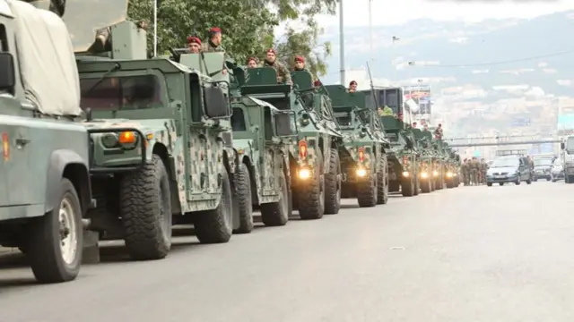 Army vehicles in a queue